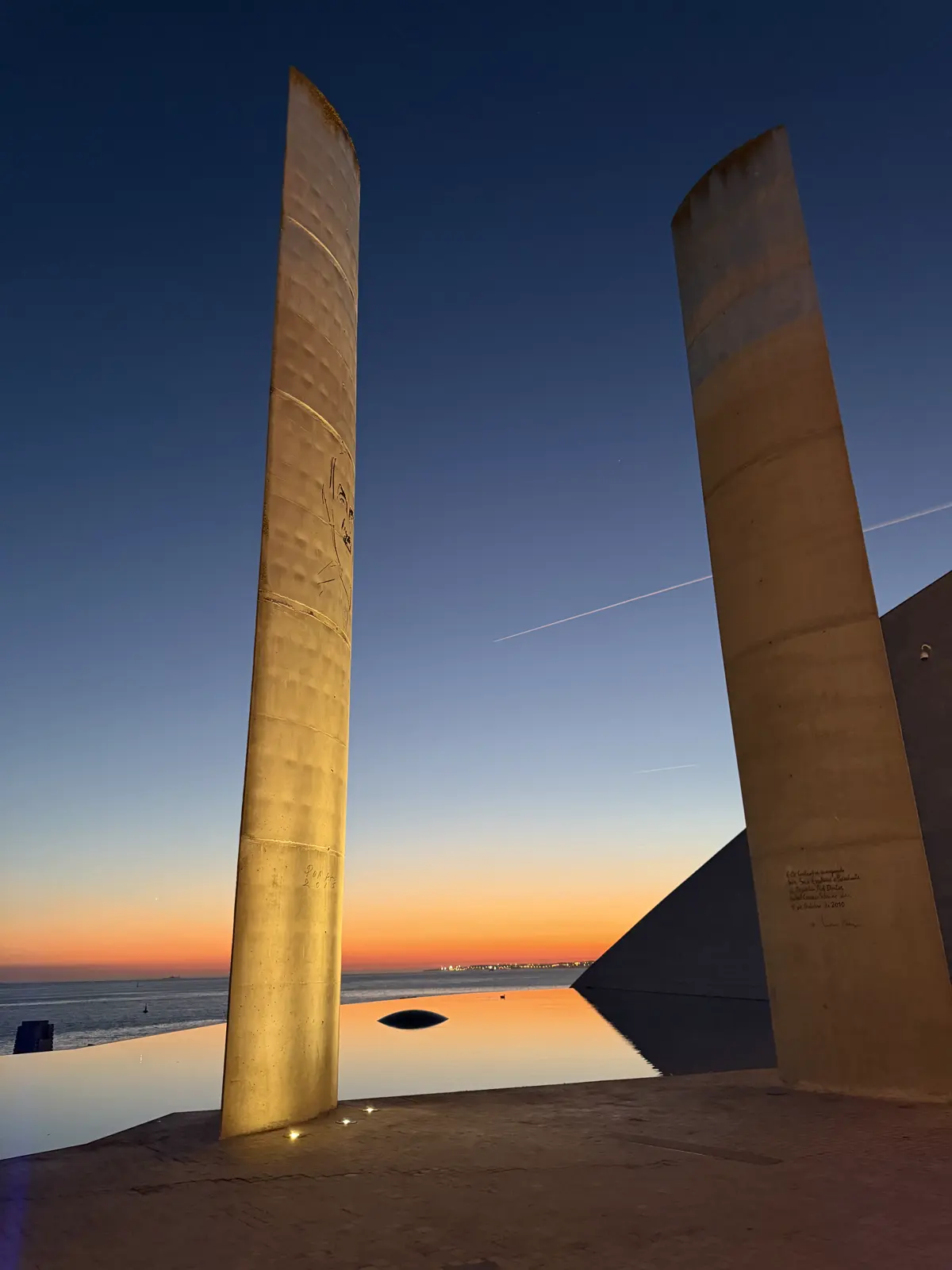The two monoliths lit from below, with the orange and blue dusk sky behind them.