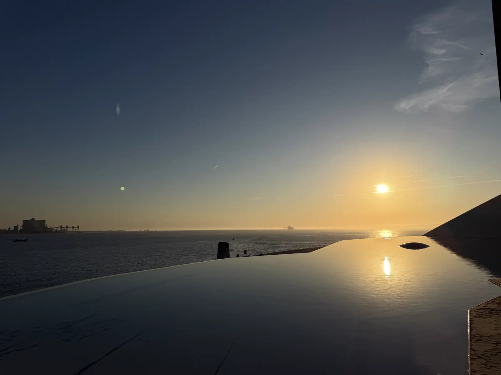 The low sun over the river and its reflection in the still water of the pool.